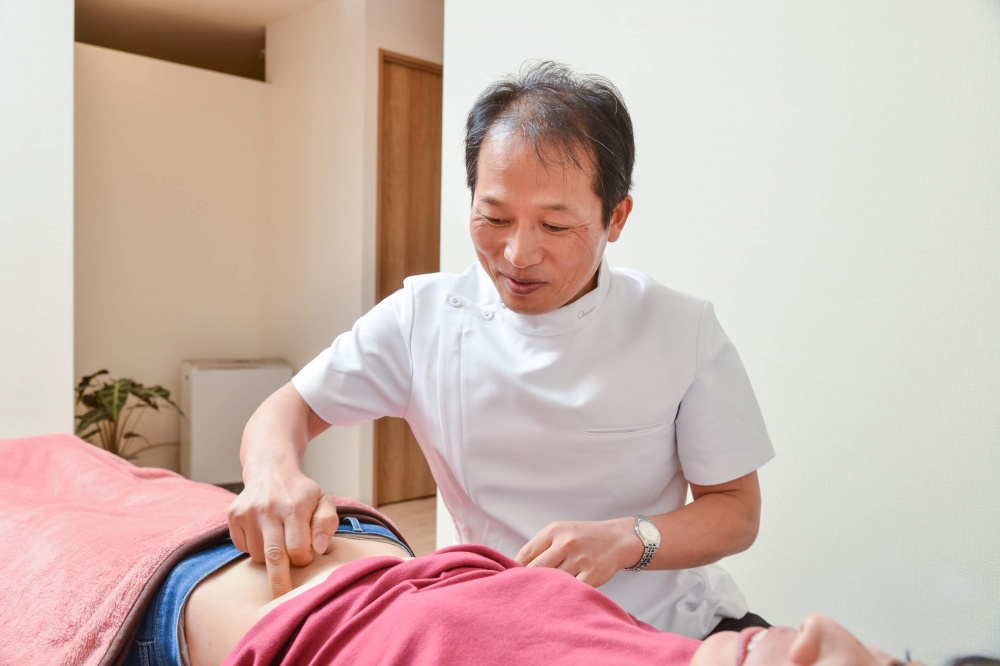 お腹ほぐしで残ったコリをほぐす施術の様子